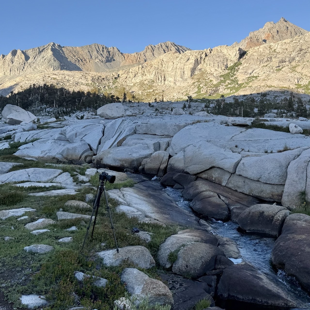 A camera on a tripod beside a creek running over granite slabs in the Big Arroyo, High Sierra Trail