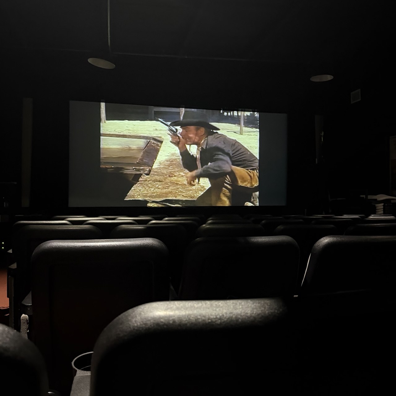 A small movie theater inside the Museum of Western Film History in Lone Pine showing a western on screen