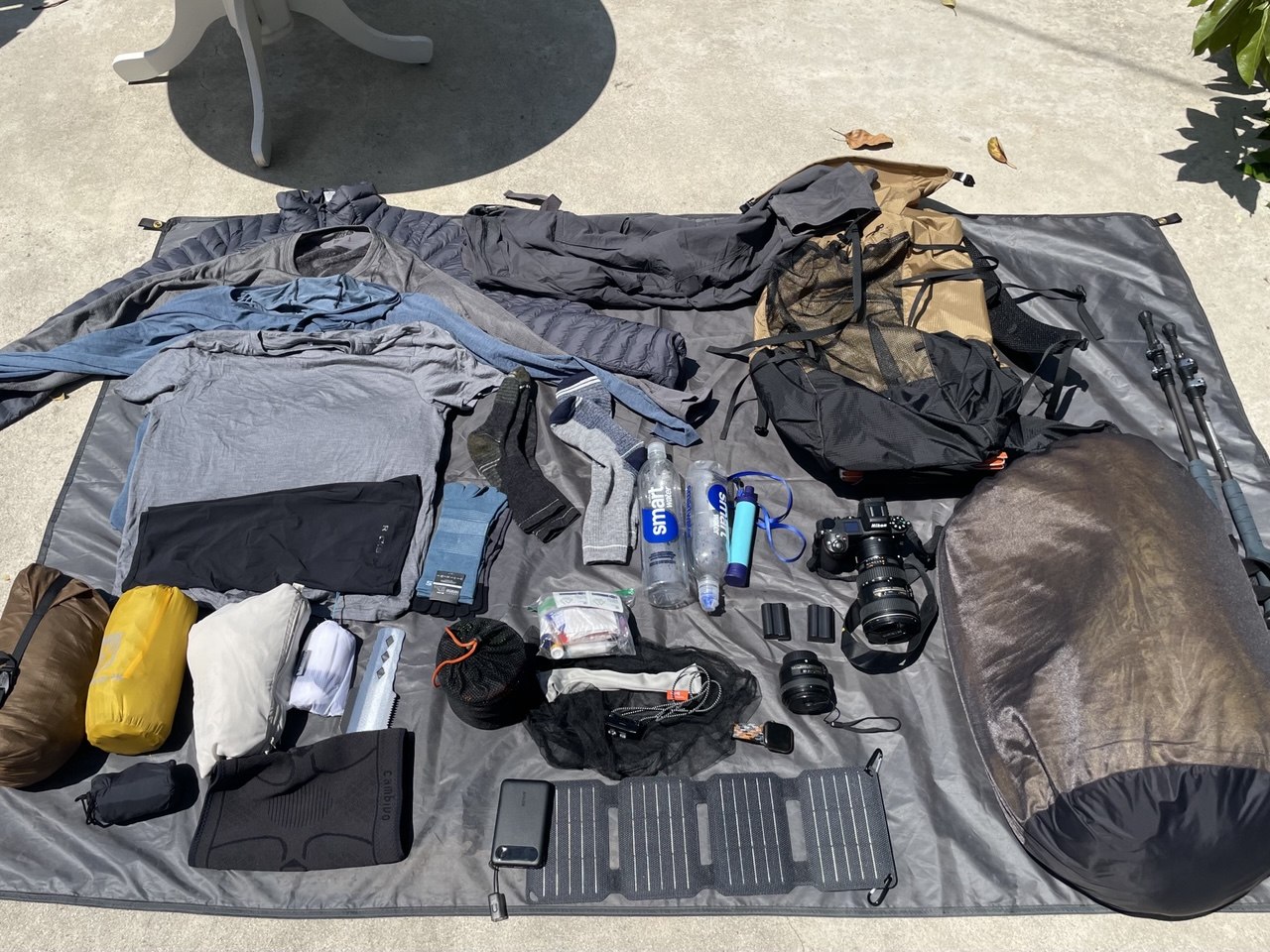 Ultralight backpacking gear and camera equipment for the John Muir Trail laid out on a groundsheet before the hike