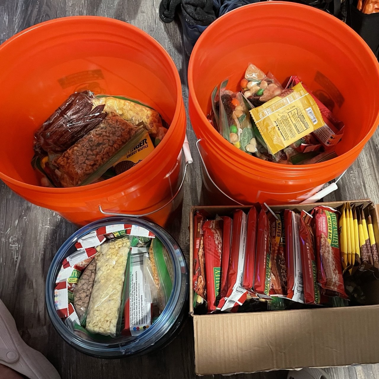 Orange five-gallon resupply buckets packed with backpacking food for the Muir Trail Ranch resupply on the John Muir Trail