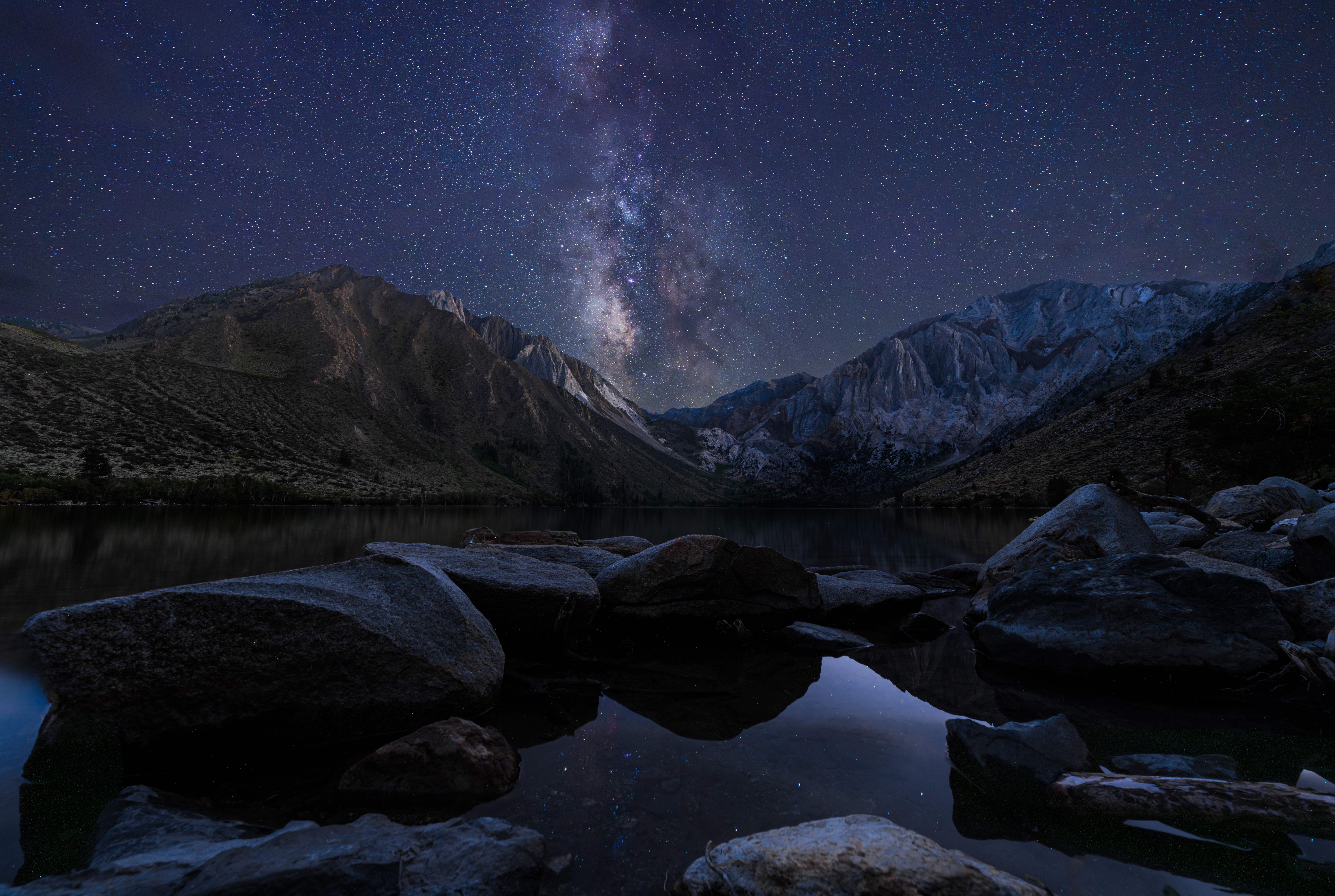 Convict Lake at midnight under the Milky Way, Mount Morrison and Laurel Mountain lit by long exposure, California.
