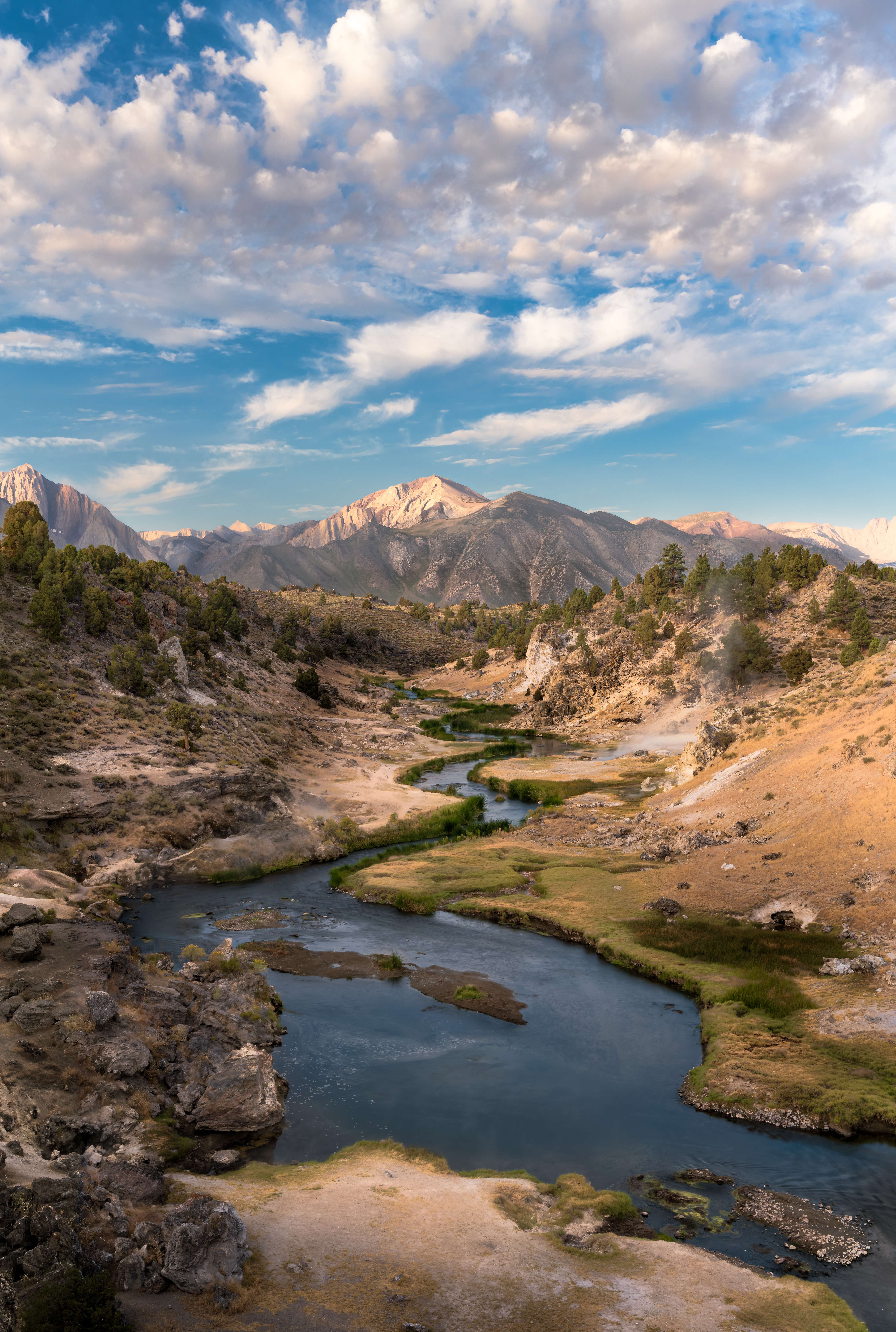 Hot Creek winding through its gorge, faint steam over the water and morning light on Mammoth Mountain, California.