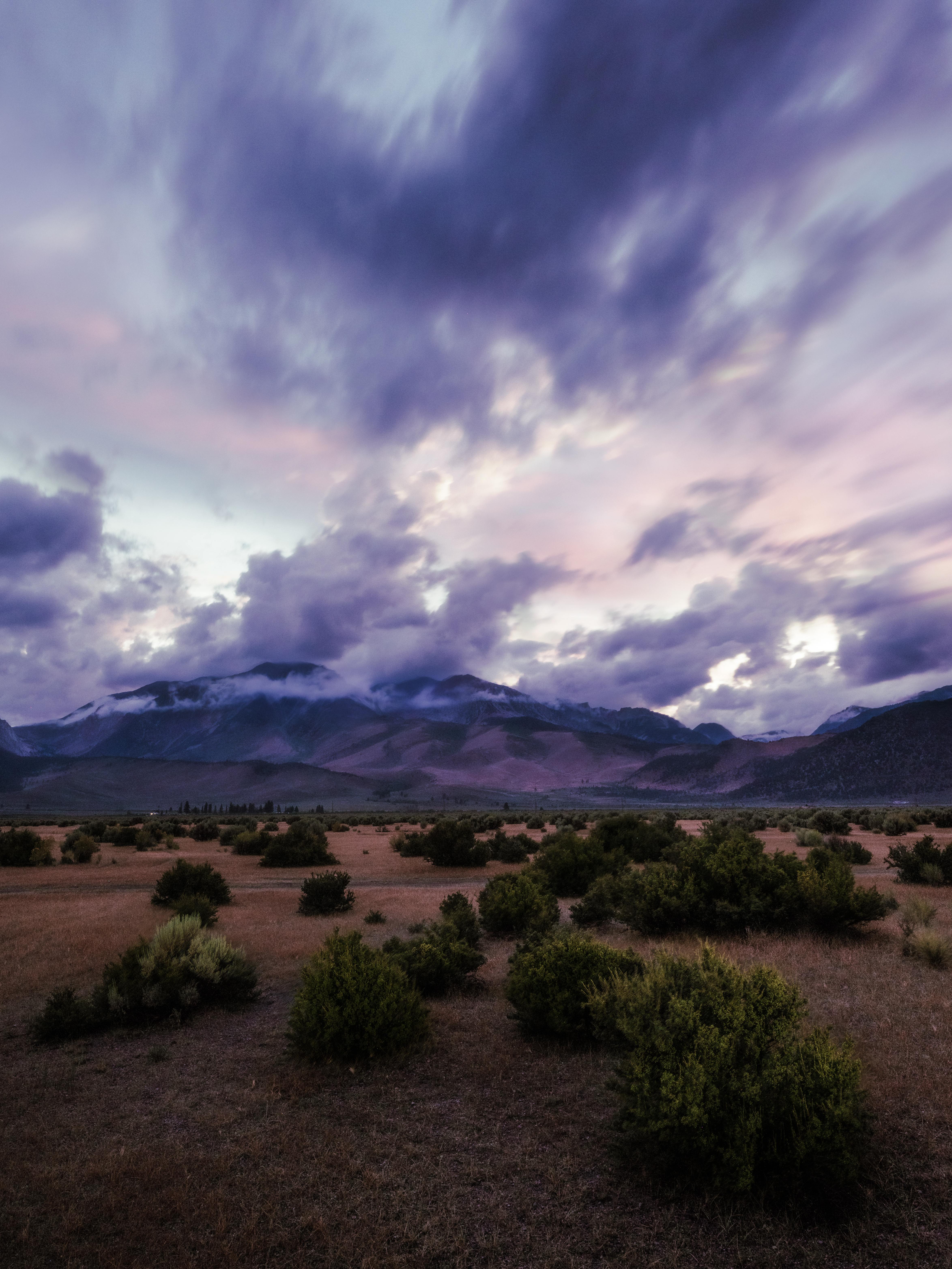 Williams Butte and the Eastern Sierra at blue hour under storm clouds, sagebrush in the foreground, Lee Vining, California.