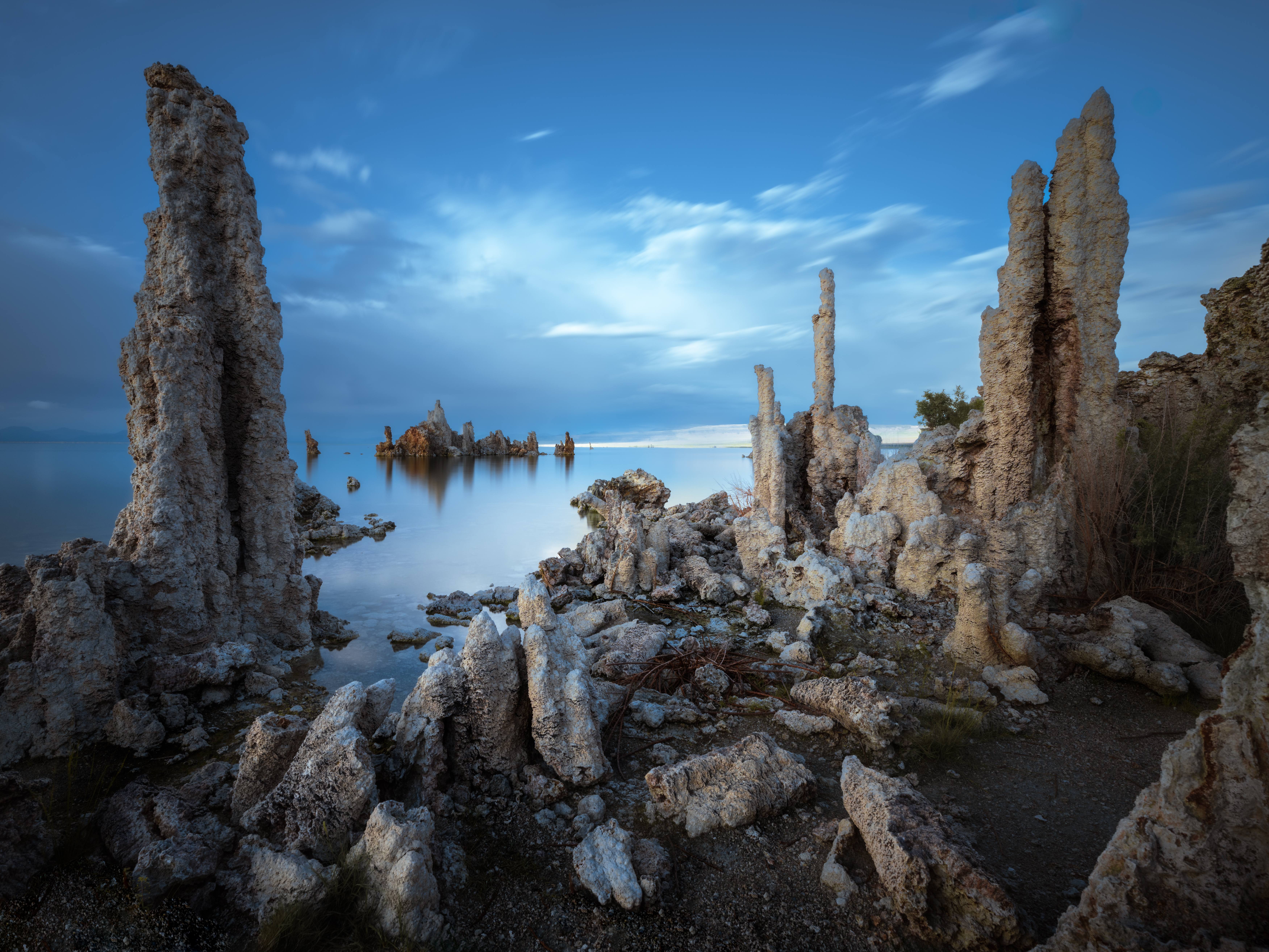 Tufa towers on the shore of Mono Lake at South Tufa in soft light before golden hour, calm water and thin cloud, California.