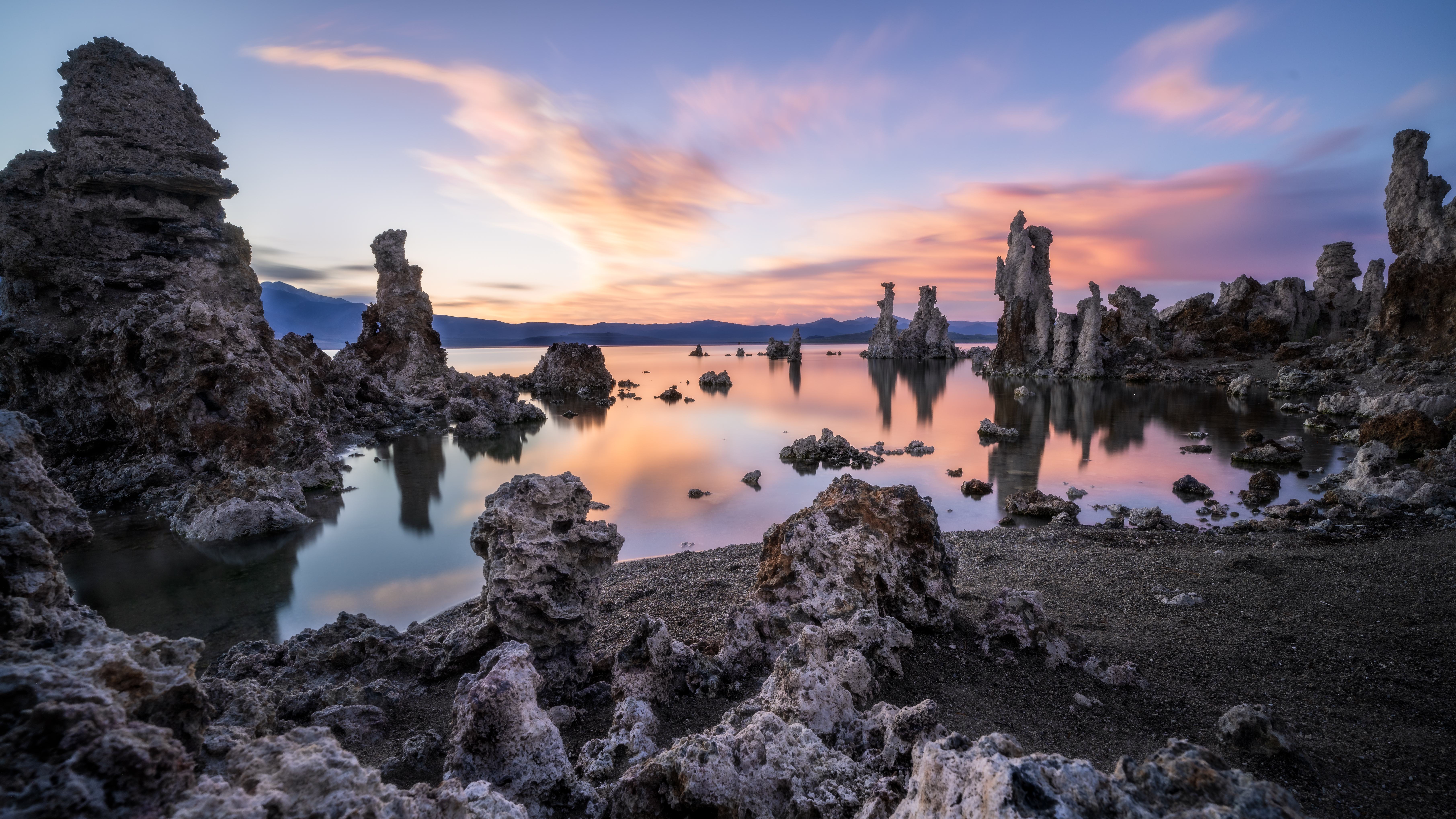 Tufa towers reflected in Mono Lake at golden hour, receding storm clouds lit warm over South Tufa, California.